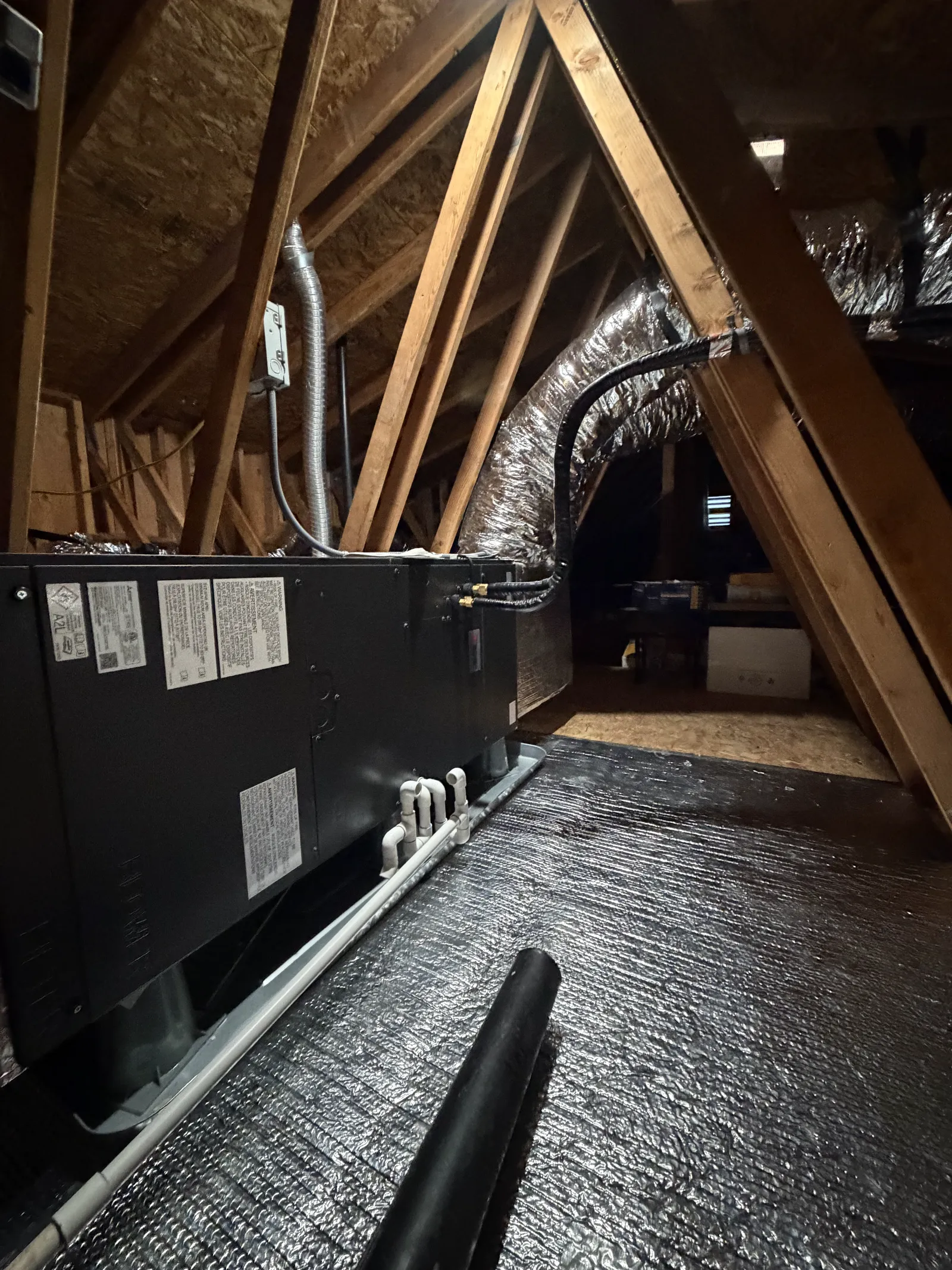 Completed attic HVAC installation with reflective floor protection